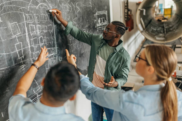 Accueil african american student explaining to his students in front of the blackboard